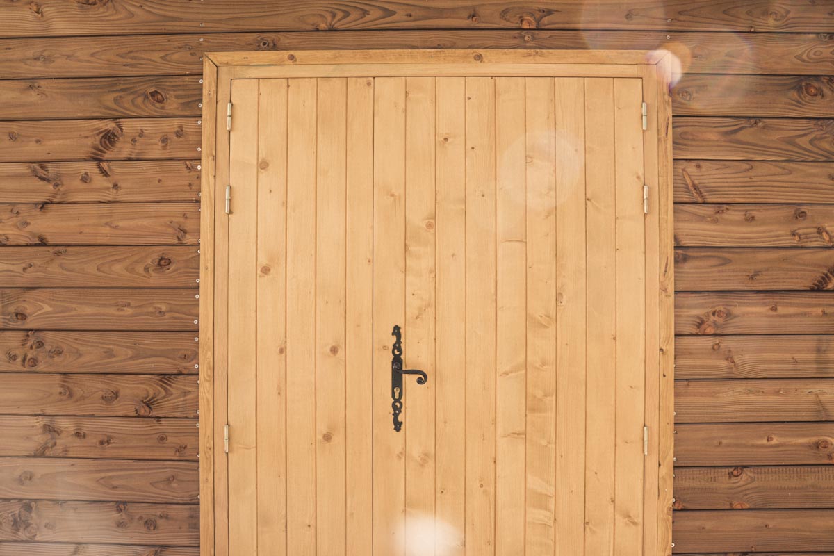 Belle porte en bois réalisée sur mesure sur un atelier